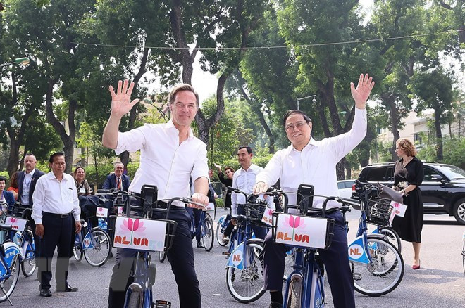 Thủ tướng Phạm Minh Chính và Thủ tướng Hà Lan Mark Rutte trên phố Hà Nội. (Ảnh: Dương Giang/TTXVN)