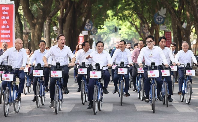 Thủ tướng Phạm Minh Chính và Thủ tướng Hà Lan Mark Rutte đạp xe tham quan không gian của Thủ đô. (Ảnh: Dương Giang/TTXVN)