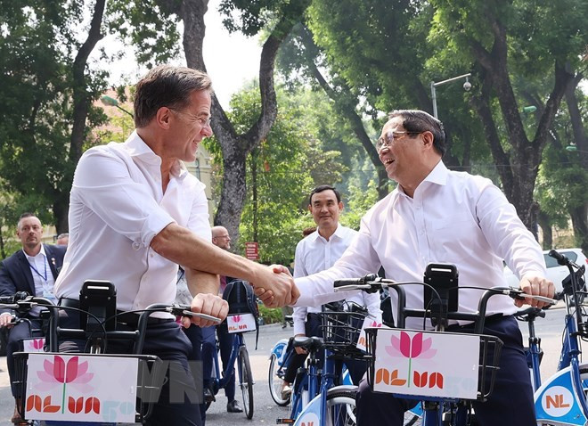 Thủ tướng Phạm Minh Chính và Thủ tướng Hà Lan Mark Rutte trên phố Hà Nội. (Ảnh: Dương Giang/TTXVN)