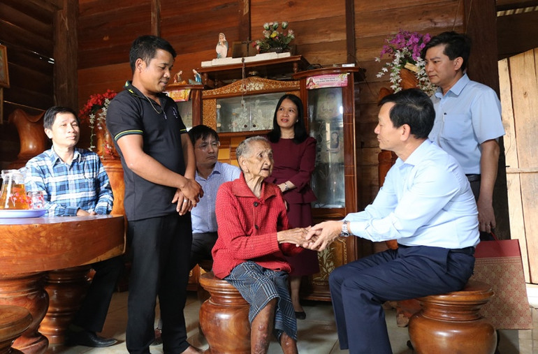 Đồng chí Dương Văn Trang (thứ hai từ phải sang) thăm hỏi và tặng quà cho bà Y Bắp, 105 tuổi, tại làng Vai Trang, xã Đăk Long, huyện Đăk Glei.