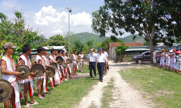 Bà con Rơ Măm tại làng Le, xã Mô Rai, huyện Sa Thầy đón đồng chí Dương Văn Trang (đi đầu) và đoàn công tác đến làm việc với làng.