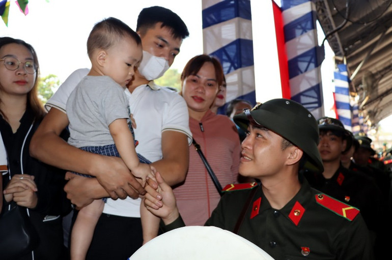 Gia đình và con trai 19 tháng tuổi đến tiễn tân binh Phan Quốc Tuấn lên đường tham gia nghĩa vụ Công an nhân dân tại điểm giao nhận quân thành phố Biên Hòa.