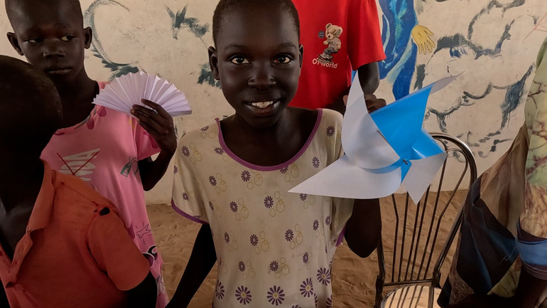 Các em nhỏ thích thú với những món đồ chơi được làm bằng giấy.