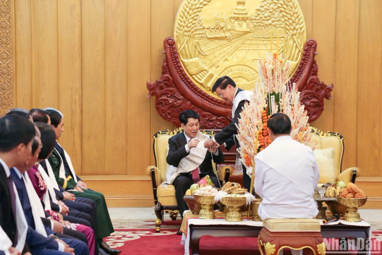 Hai nhà lãnh đạo Lễ buộc chỉ cổ tay nhân dịp đầu năm mới, Tết cổ truyền Bunpimay của Lào. Hai nhà lãnh đạo Lễ buộc chỉ cổ tay nhân dịp đầu năm mới, Tết cổ truyền Bunpimay của Lào.