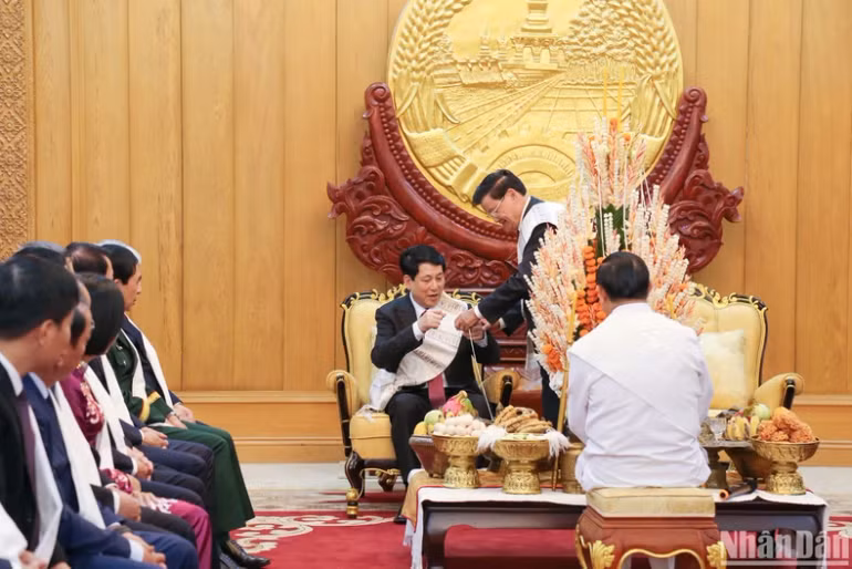 Hai nhà lãnh đạo Lễ buộc chỉ cổ tay nhân dịp đầu năm mới, Tết cổ truyền Bunpimay của Lào. Hai nhà lãnh đạo Lễ buộc chỉ cổ tay nhân dịp đầu năm mới, Tết cổ truyền Bunpimay của Lào.