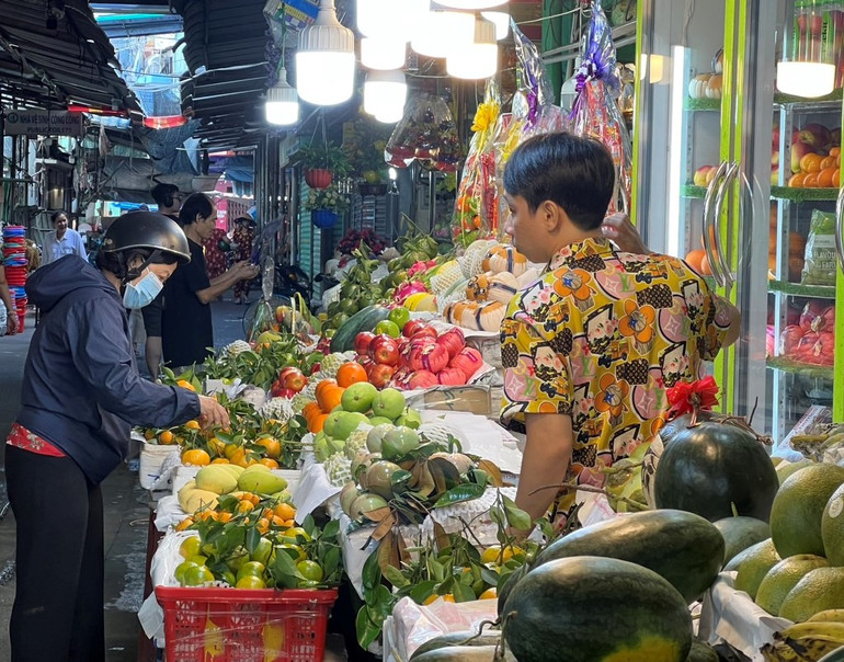 Người dân chọn mua trái cây tại chợ Tân Định, quận 1, Thành phố Hồ Chí Minh, sáng mùng 4 Tết. (Ảnh: Hoàng Liêm)