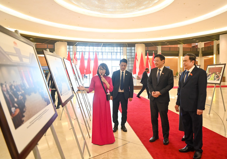 Chủ tịch Quốc hội Trần Thanh Mẫn và Thủ tướng Singapore Lawrence Wong xem trưng bày ảnh về quan hệ Việt Nam-Singapore. (Ảnh Duy Linh)