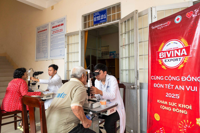 Người dân được chăm sóc sức khỏe và khám mắt bởi các chuyên viên y tế.