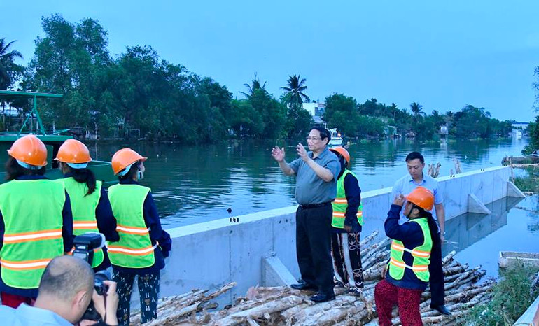 Thủ tướng Phạm Minh Chính nói chuyện với công nhân đang thi công dự án kè chống sạt lở khẩn cấp sông Trà Nóc.