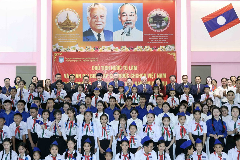 Chủ tịch nước Tô Lâm và các đại biểu chụp ảnh chung với thầy cô giáo và học sinh Trường song ngữ Lào-Việt Nam. Ảnh: Nhan Sáng-TTXVN