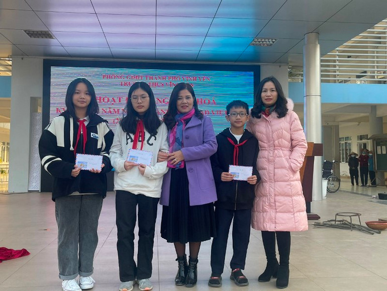 Hiệu trưởng Triệu Thị Thanh Hà (giữa) tặng quà cho học sinh tham gia hoạt động ngoại khóa.