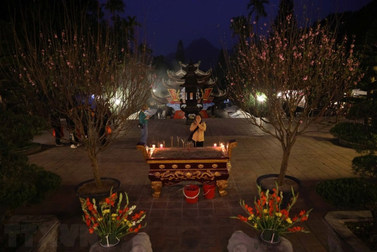 Người dân và du khách dâng hương, lễ Phật trước giờ khai hội chùa Hương. (Ảnh: TTXVN)