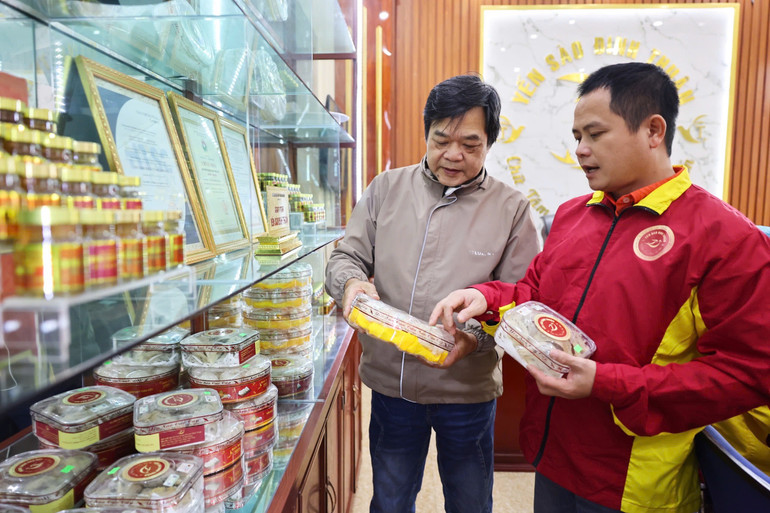 Anh Đinh Văn Thuận (người bên phải) giới thiệu sản phẩm từ tổ yến với khách hàng. (Ảnh: Trường Huy)