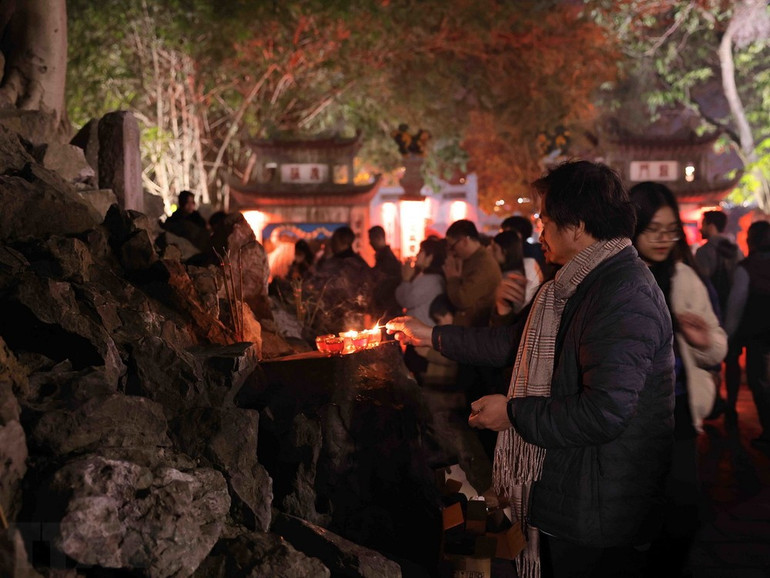 Nhiều người dân đến đền Ngọc Sơn ngay sau thời khắc đón năm mới Giáp Thìn. (Ảnh: Hoàng Hiếu/TTXVN)