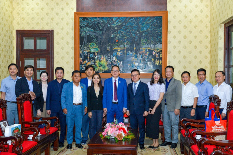 Tổng Biên tập Báo Nhân Dân Lê Quốc Minh, Chủ tịch Câu lạc bộ các nhà báo Campuchia Puy Kea cùng các đại biểu chụp hình lưu niệm tại buổi tiếp.