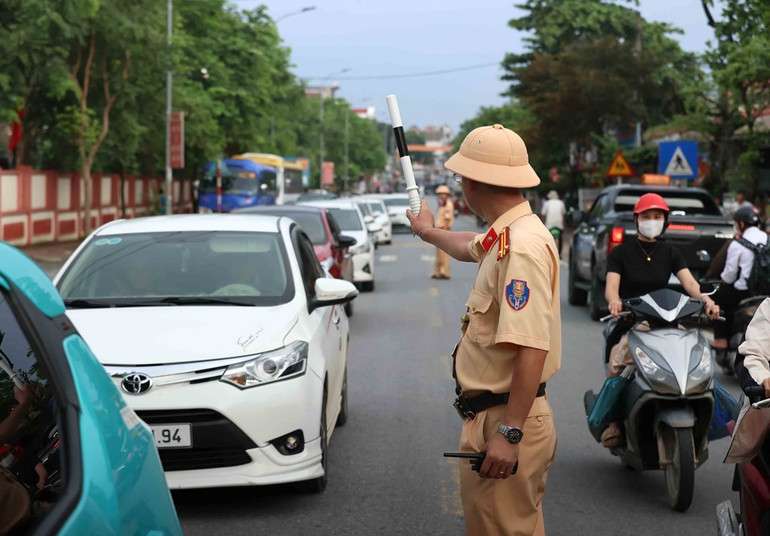 Cảnh sát giao thông phân luồng cho các hướng vào cầu phao Phong Châu. Ảnh: An Đăng - TTXVN