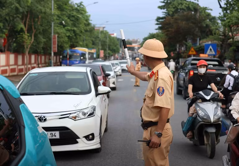 Cảnh sát giao thông phân luồng cho các hướng vào cầu phao Phong Châu. Ảnh: An Đăng - TTXVN