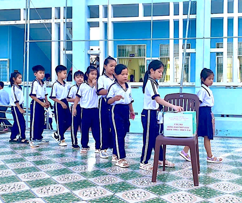 Học sinh nhiều trườngvùng sâu, vùng xa ở Cà Mau quyên góp tiền ủng hộ học sinh vùng bị ảnh hưởng bởi thiên tai phía bắc. (Ảnh: Hữu Tùng)