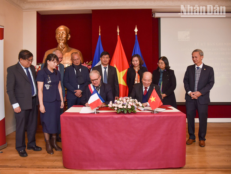 Ông Phạm Ngọc Nghị, Chủ tịch UBND tỉnh Đắk Lắk, và ông Denis Thuriot, Thị trưởng thành phố Nevers, ký kết văn bản thỏa thuận hợp tác giữa hai chính quyền địa phương. (Ảnh: MINH DUY)