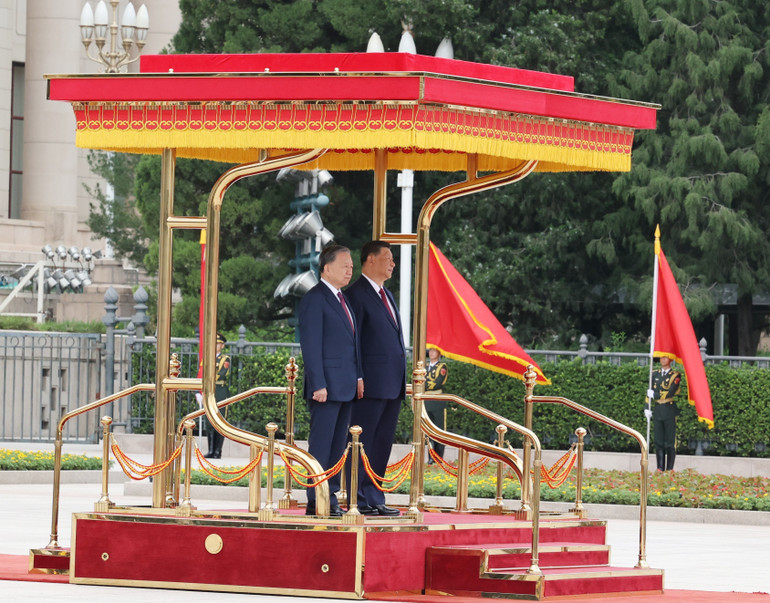 Tổng Bí thư, Chủ tịch nước Tô Lâm và Tổng Bí thư, Chủ tịch nước Trung Quốc Tập Cận Bình trên bục danh dự, nghe quân nhạc cử Quốc thiều hai nước. Ảnh: Trí Dũng – TTXVN