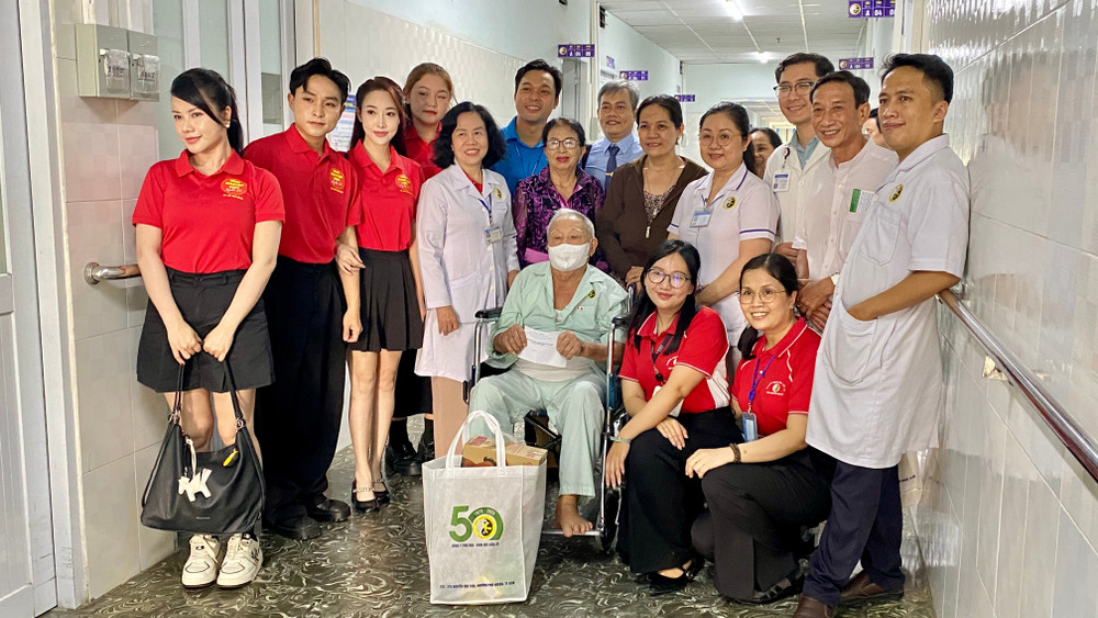 Y bác sĩ trao quà cho bệnh nhân lớn tuổi tại Viện Y dược học dân tộc Thành phố Hồ Chí Minh.