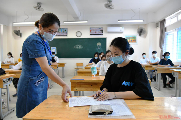 Cán bộ coi thi hướng dẫn thí sinh hoàn thiện thủ tục dự thi tại điểm thi Trường THCS Phan Chu Trinh (quận Ba Đình). Học sinh Hà Nội sẵn sàng cho Kỳ thi tốt nghiệp THPT năm 2021 -0