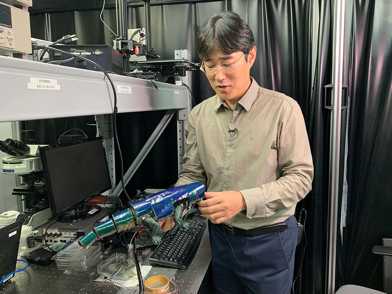 Giáo sư Ko Seung-hwan, Đại học Quốc gia Seoul và robot Chameleon được phủ da nhân tạo. Ảnh: Reuters. Hàn Quốc chế tạo thành công da nhân tạo đổi màu giống tắc kè hoa -0