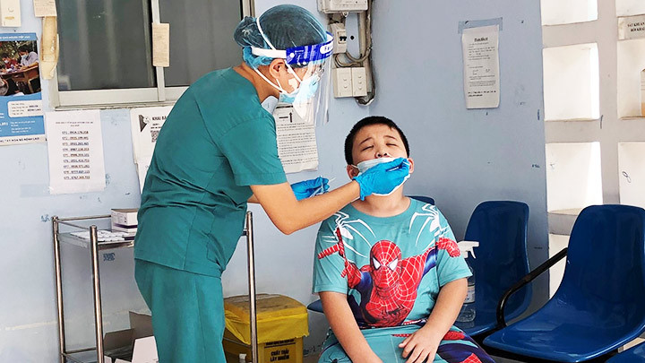 Nhân viên y tế địa phương lấy mẫu xét nghiệm Covid-19 cho một trường hợp nghi nhiễm. Nâng cấp phòng dịch tại trường học -0
