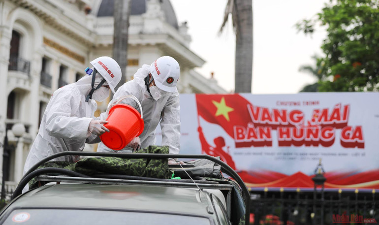 Các chiến sĩ tiến hành các công tác chuẩn bị khí tài, pha thuốc. Dung dịch phun khử khuẩn là CloraminB. 3Ha_noi_khu_khuan-1627273703849.jpeg