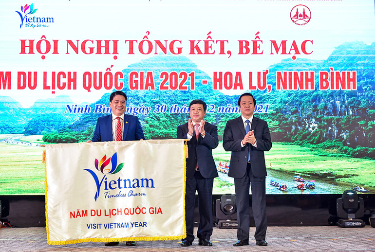Phó Chủ tịch Ủy ban nhân dân tỉnh Quảng Nam Trần Văn Tân nhận cờ luân lưu đăng cai Năm Du lịch Quốc gia 2022. (Ảnh: Tổng cục Du lịch) Năm Du lịch Quốc gia 2022: “Quảng Nam – Điểm đến du lịch xanh” -0