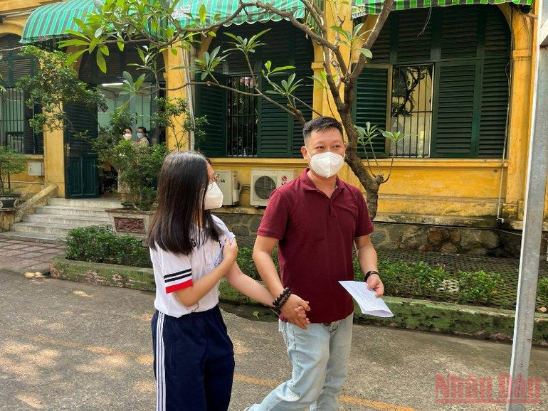 Anh Hoàng Minh Tuấn và con vui vẻ sau khi tiêm mũi vaccine phòng Coivd-19 đầu tiên cho cháu. Thành phố Hồ Chí Minh chính thức tiêm vaccine phòng Covid-19 cho trẻ dưới 12 tuổi -0
