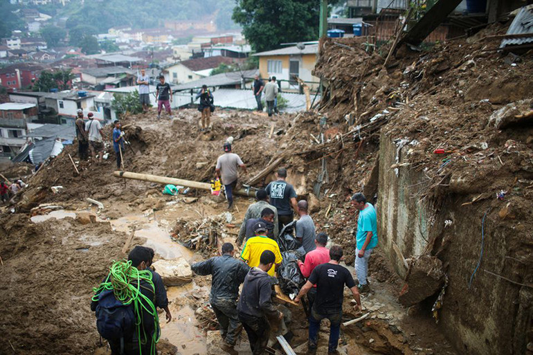 Người dân di chuyển thi thể được tìm thấy tại khu vực Morro da Oficina. (Ảnh: Reuters) Brazil -4