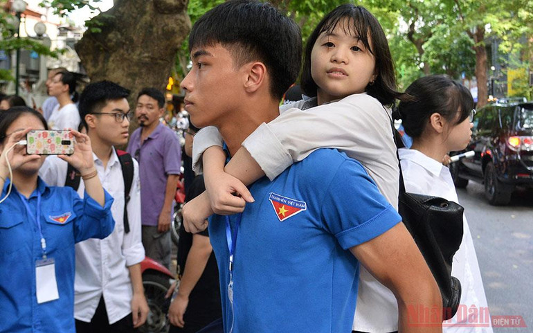 Lực lượng thanh niên tình nguyện đưa thí sinh gặp vấn đề về sức khỏe ra khu vực phụ huynh đang chờ sau buổi thi môn Ngoại ngữ. 8-1595064677652.jpg