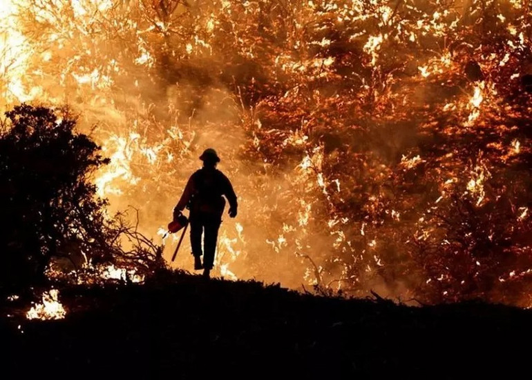 Một nhân viên cứu hỏa đối diện với đám cháy Caldor ở bang California, Mỹ hồi tháng 8. (Ảnh: Reuters) 10 bức ảnh ấn tượng về môi trường năm 2021 -0