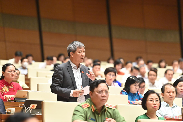 Đại biểu Nguyễn Anh Trí tranh luận về vấn đề giá sách giáo khoa tại phiên chất vấn của Quốc hội sáng 8/6. (Ảnh: NGUYÊN KHOA) Đề xuất đưa sách giáo khoa vào danh mục hàng hóa được Nhà nước định giá -0