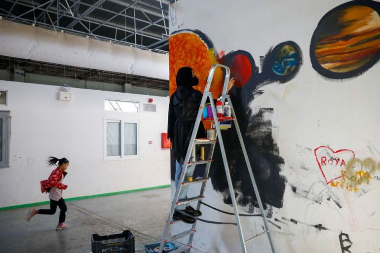 Rasuli hoàn thiện bức tranh tường tại trại tị Thiva. (Ảnh: REUTERS) Từ trại tị nạn Hy Lạp, cô gái Afghanistan truyền cảm hứng trao quyền cho phụ nữ -0
