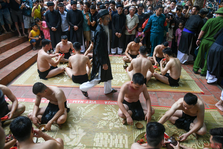 16 thanh niên khỏe mạnh tham gia gọi là quân cầu, chia làm 2 giáp trên và dưới, mỗi giáp 8 người. Tất cả đóng khố, cởi trần. Trước khi ra vật cầu họ làm lễ ở sân đền, uống rượu và ăn hoa quả để tăng dũng khí. Bắc Giang: Độc đáo thanh niên đóng khố “vật cầu bùn” -0