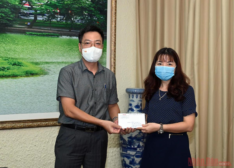 Đồng chí Phan Huy Thắng, Ủy viên Ban Biên tập, Trưởng Ban Thư ký - Biên tập Báo Nhân Dân trao quà hỗ trợ của các cựu sinh viên Khoa Báo chí cho đại diện nhà trường. Báo Nhân Dân trao 200 triệu đồng hỗ trợ sinh viên bị ảnh hưởng dịch bệnh Covid-19 -0
