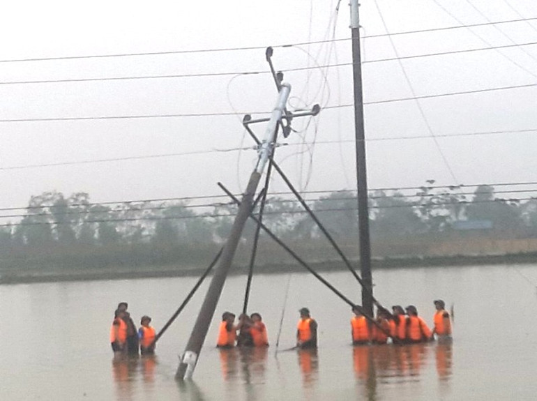 Lực lượng bộ đội hỗ trợ dựng lại cột điện cao thế bị nghiêng. Điện lực Nghệ An cấp điện trở lại cho toàn bộ khách hàng -0