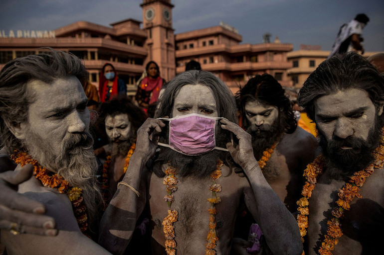 Một Naga Sadhu - tu sĩ khổ hạnh theo đạo Hindu - đeo khẩu trang trước khi ngâm mình trên sông Hằng trong lễ Kumbh Mela tại TP Haridwar, ngày 12/4/2021. Số ca mắc và tử vong do Covid-19 đã tăng mạnh tại Ấn Độ trong tháng 4 và 5/2021. Trong thời gian cao điểm của đại dịch, nhiều bệnh viện tại nước này đã bị thiếu oxy y tế, khiến nhiều bệnh nhân tử vong. (Ảnh: REUTERS/Danish Siddiqui) Loạt ảnh về đại dịch Covid-19 tại Ấn Độ của Reuters giành giải Pulitzer 2022 -0