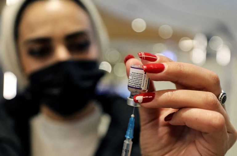 Nhân viên y tế chuẩn bị 1 liều vaccine ngừa Covid-19 của Pfizer-BioNTech, Jerusalem, ngày 22/12/2021. (Ảnh: Reuters) Australia ghi nhận ca tử vong đầu tiên trên nền nhiễm biến thể Omicron -0