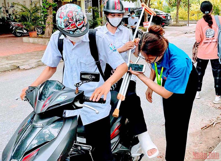 Hỗ trợ thí sinh bị thương ở chân tham dự kỳ thi. Đông đảo tình nguyện viên trên cả nước tham gia “Tiếp sức mùa thi” -0