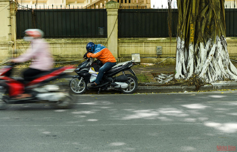 Những người làm nghề xe ôm thì tranh thủ ngủ trưa dưới bóng râm. Người dân Hà Nội chống chọi với nắng nóng gay gắt -0