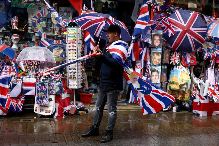 Người đàn ông bán hàng gần Cung điện Windsor, London. (Ảnh: Reuters) Vương quốc Anh sẵn sàng cho Đại lễ Bạch kim kỷ niệm 70 năm Nữ hoàng Elizabeth II lên ngôi -0
