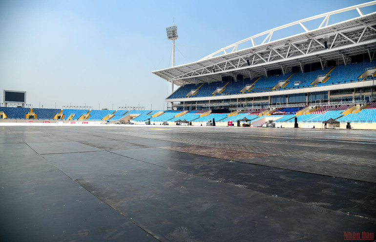 Toàn bộ mặt cỏ và đường pitch trên sân Mỹ Đình được phủ 3 lớp cốp pha nhựa, thép và ván. (Ảnh: THÀNH ĐẠT) Sân Mỹ Đình