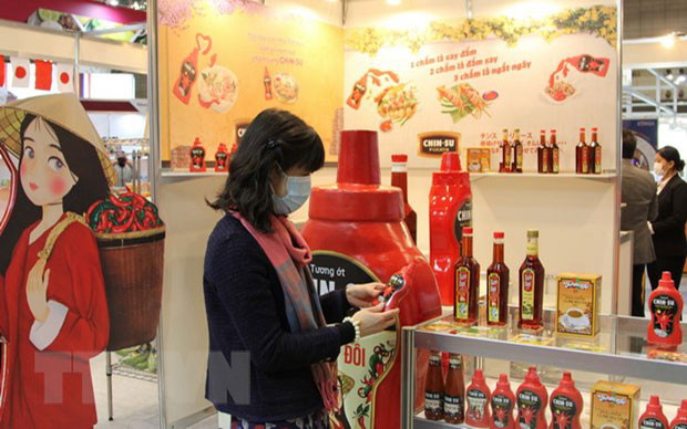 Khách tham quan tìm hiểu về sản phẩm tương ớt của Việt Nam trưng bày tại Triển lãm Thực phẩm và Đồ uống Quốc tế lần thứ 46 (Foodex Japan 2021), tại Nhật Bản. (Ảnh: TTXVN) Mở cơ hội cho mặt hàng gia vị và hương liệu Việt Nam vươn ra thế giới -0