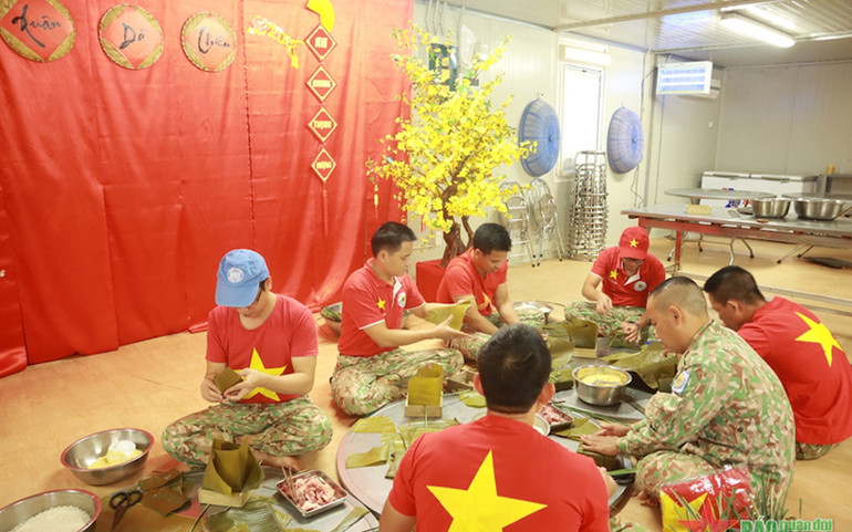 "Gia đình 2.3" quây quần gói bánh chưng trong không khí Tết. (Ảnh: Báo Quân đội Nhân dân) "Gia đình 2.3" quây quần gói bánh chưng trong không khí Tết. (Ảnh: Báo Quân đội Nhân dân)