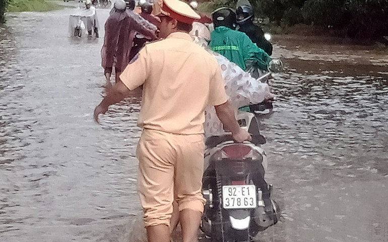 Lực lượng công an giúp người dân đi qua vùng trũng thấp ở huyện Đại Lộc. Quảng Nam nước sông dâng cao, khẩn cấp di dời dân -0