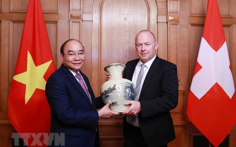 Chủ tịch nước Nguyễn Xuân Phúc tặng quà lưu niệm Chủ tịch Hội đồng Quốc gia Liên bang Thụy Sĩ Andreas Aebi. (Ảnh: Thống Nhất/TTXVN) ttxvnchu_tich_nuoc003-1637972484773.jpeg