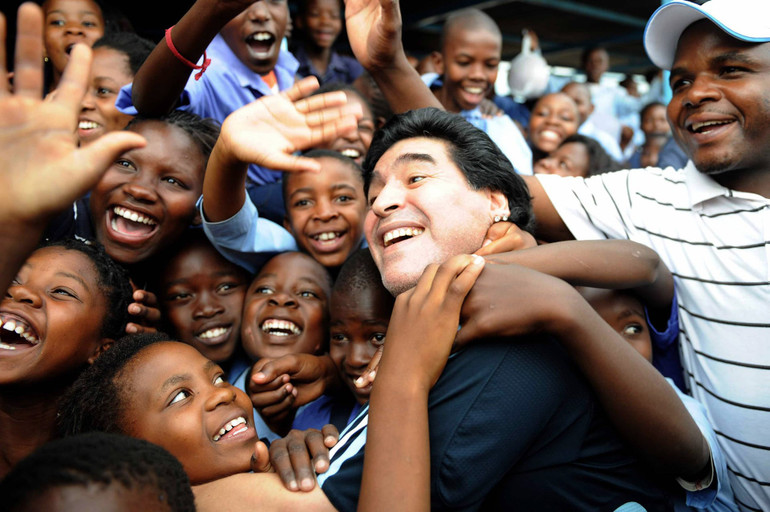 Maradona được chào đón nồng nhiệt khi đến thăm trường Kgotlelelang tại Nam Phi, tháng 1-2010, với tư cách là huấn luyện viên đội tuyển Argentina. (Ảnh: Getty Images) Cuộc đời và sự nghiệp của huyền thoại Maradona qua ảnh -0